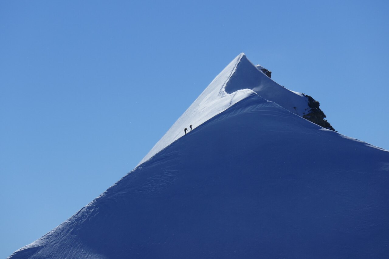 Trekkers resting at a high-altitude Himalayan teahouse beneath snow peaks