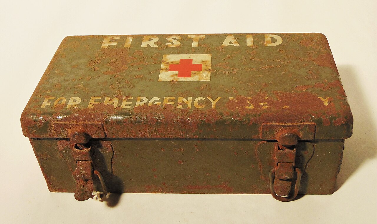 Ultralight first-aid kit contents arranged on a hiking map: leukotape, blister pads, tweezers and mini pill bags